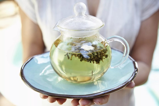 kobieta dzbanek do herbaty z zieloną herbatą